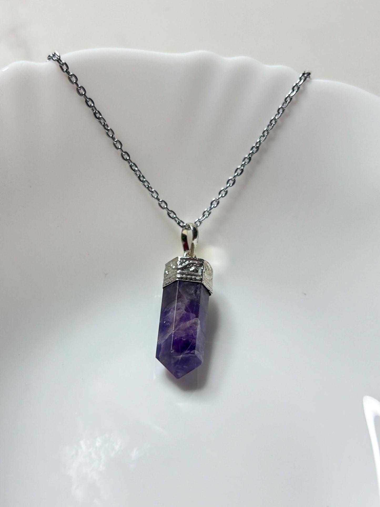 Amethyst pencil pendant on a silver chain, promoting intuition, protection, and self-healing energy.